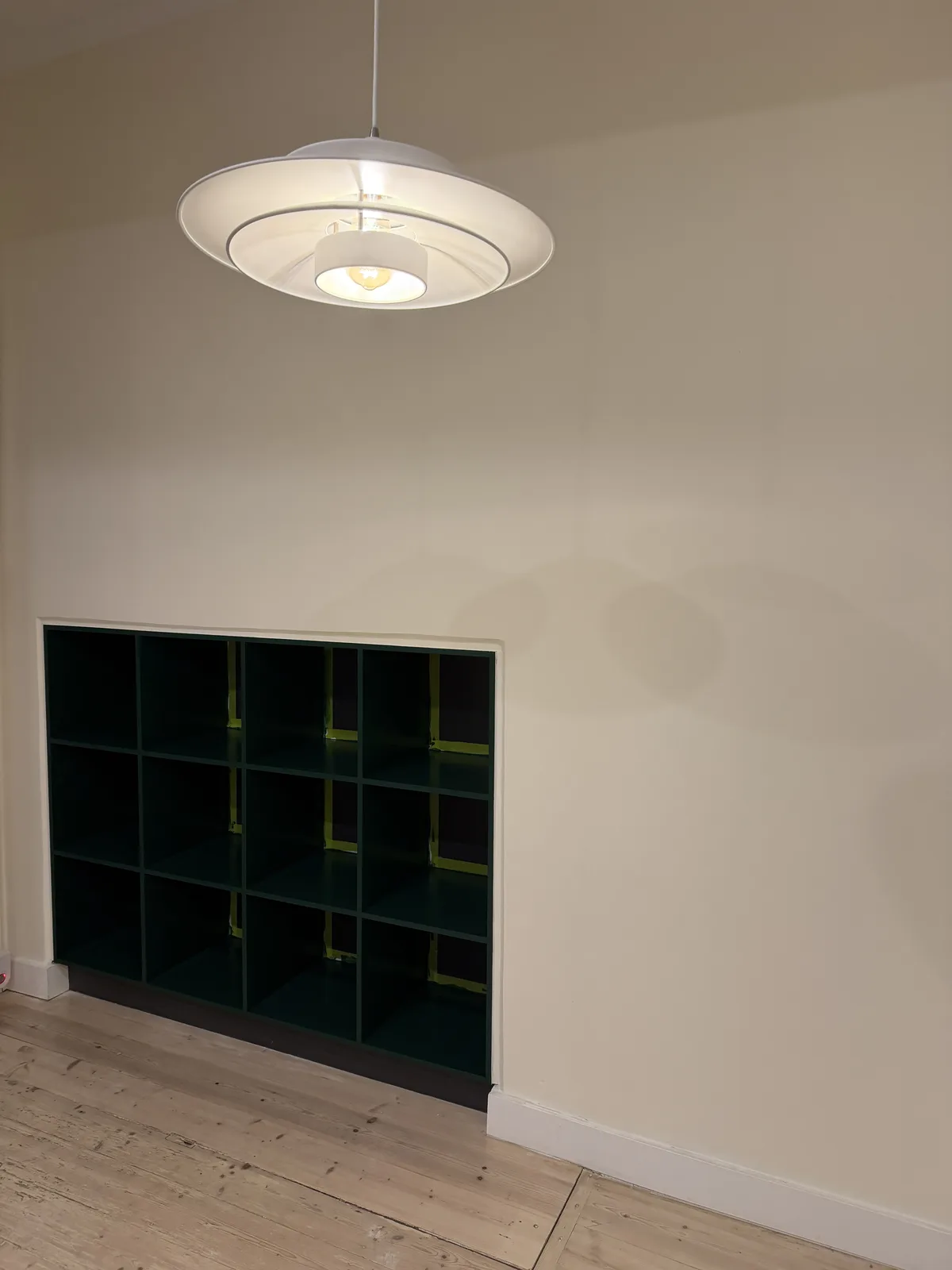 Interior wall above green shelving after crack repairs and repainting